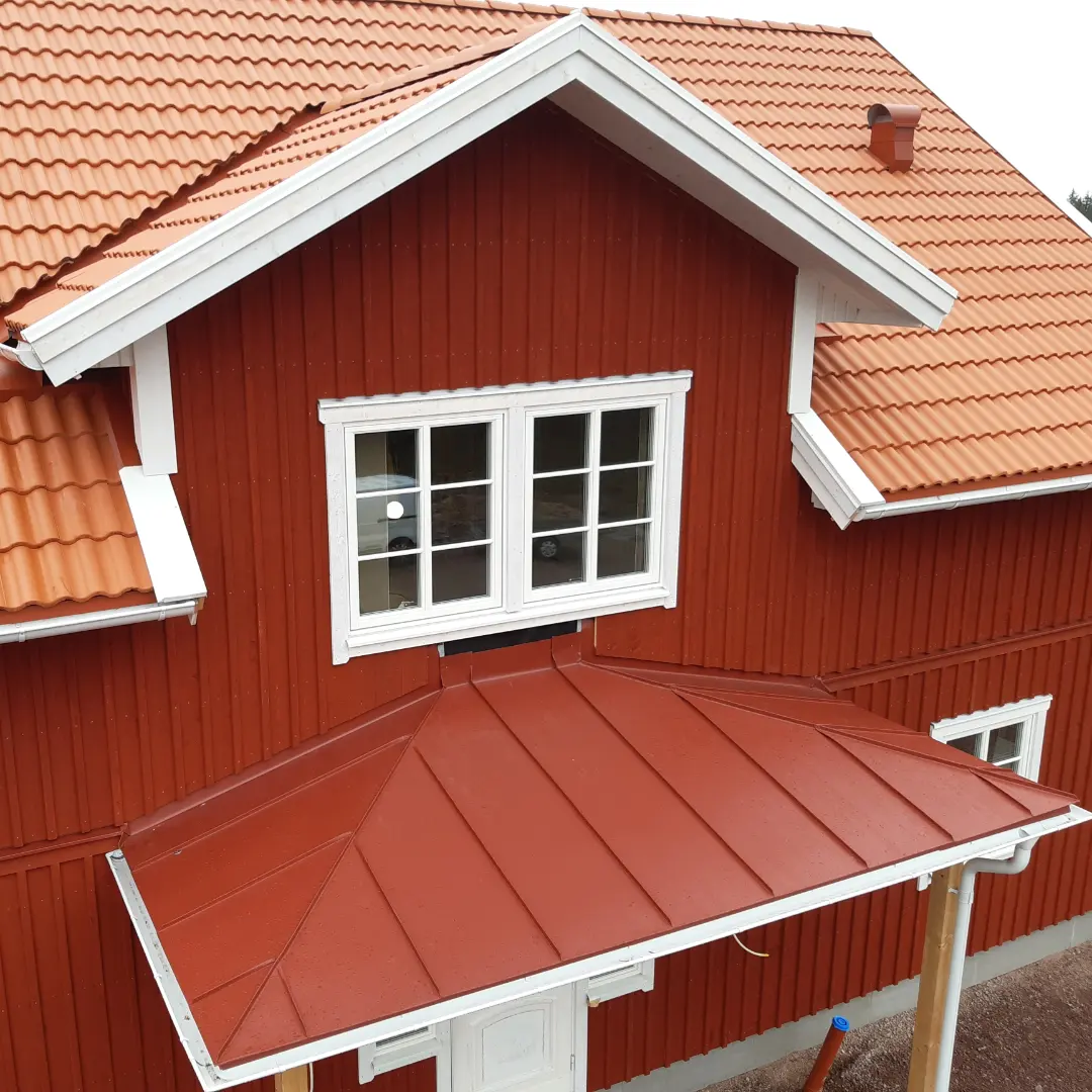 Bandtäckt tak över farstukvist på nybyggt lösvirkeshus