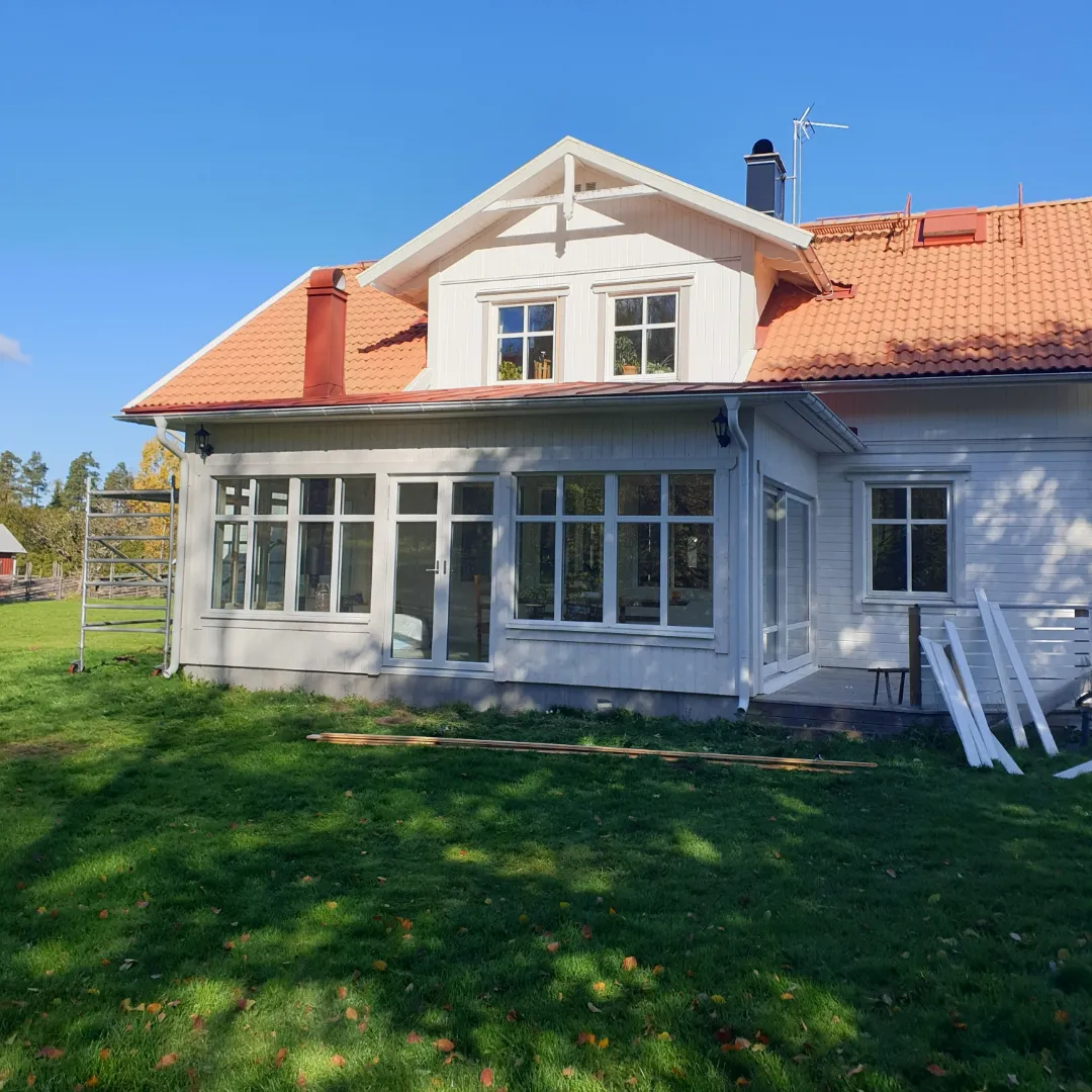 Tillbyggnad med tegelröd bandtäckning, bleck och takavvattning