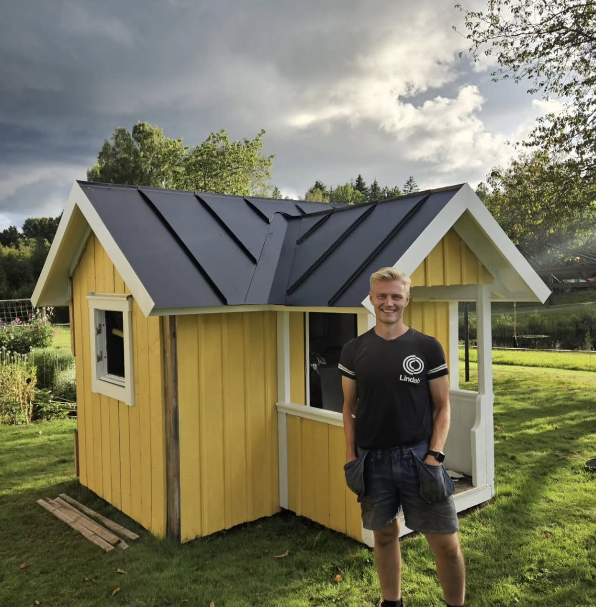 Christoffer Arvidsdal framför ett gult hus med nytäckt mörkgrått plåttak
