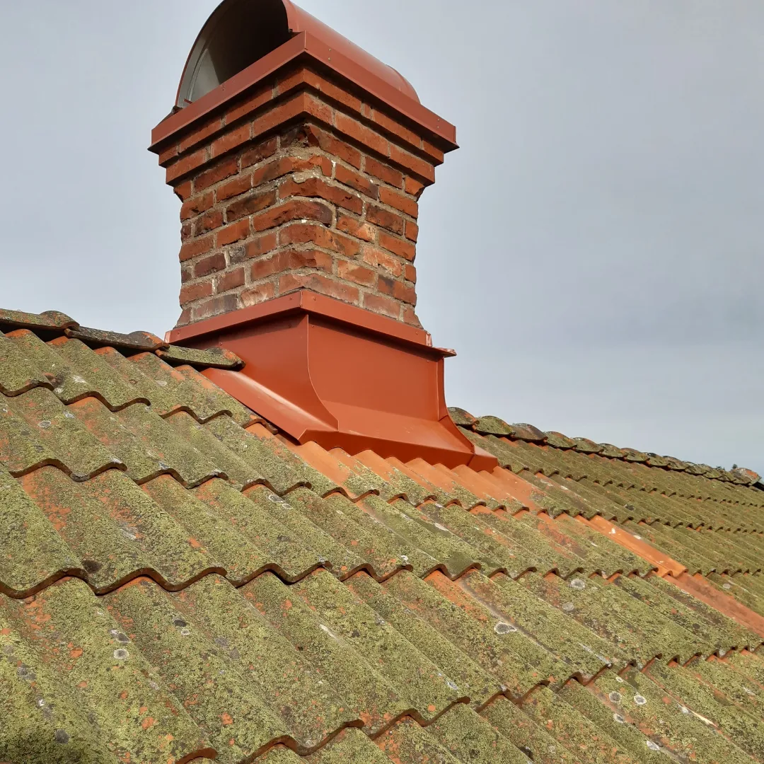 Nederbeslag i tegelrött på murad skorsten