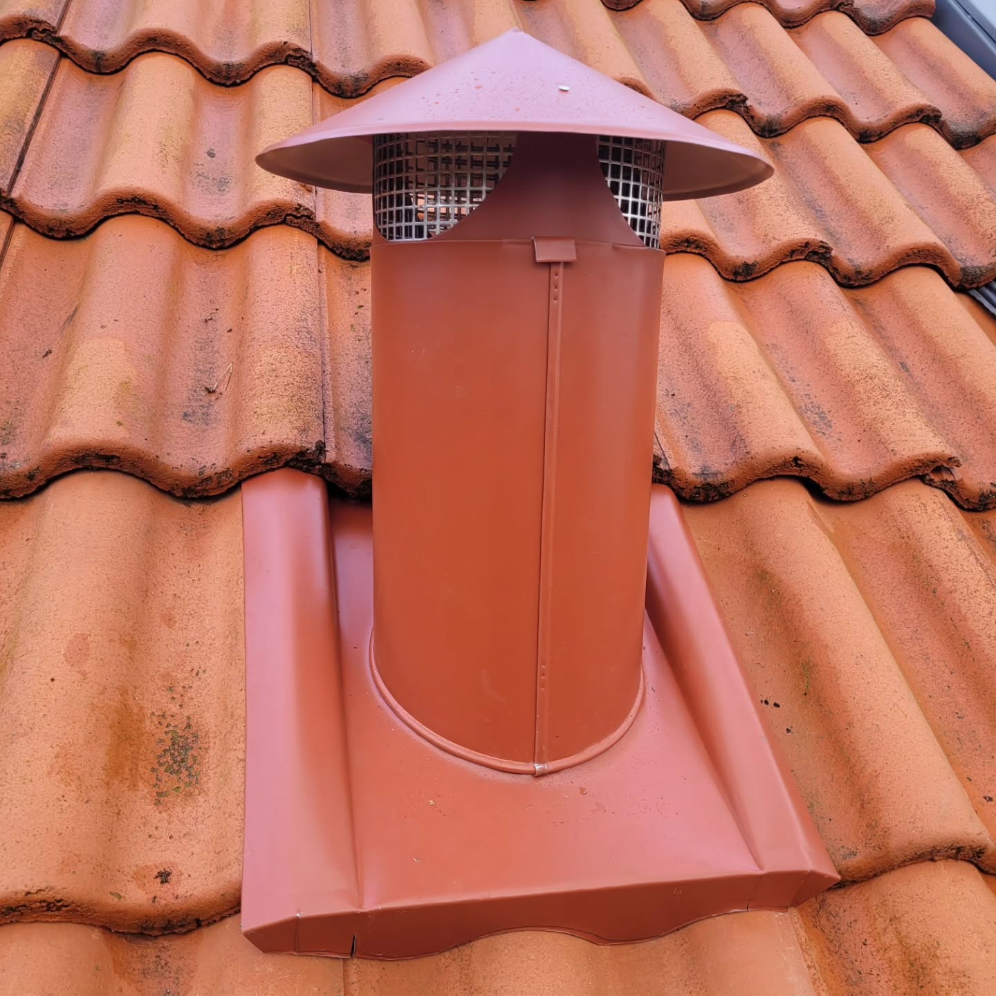 Ventilationshuv i tegelrött, tillverkad för just det här taket